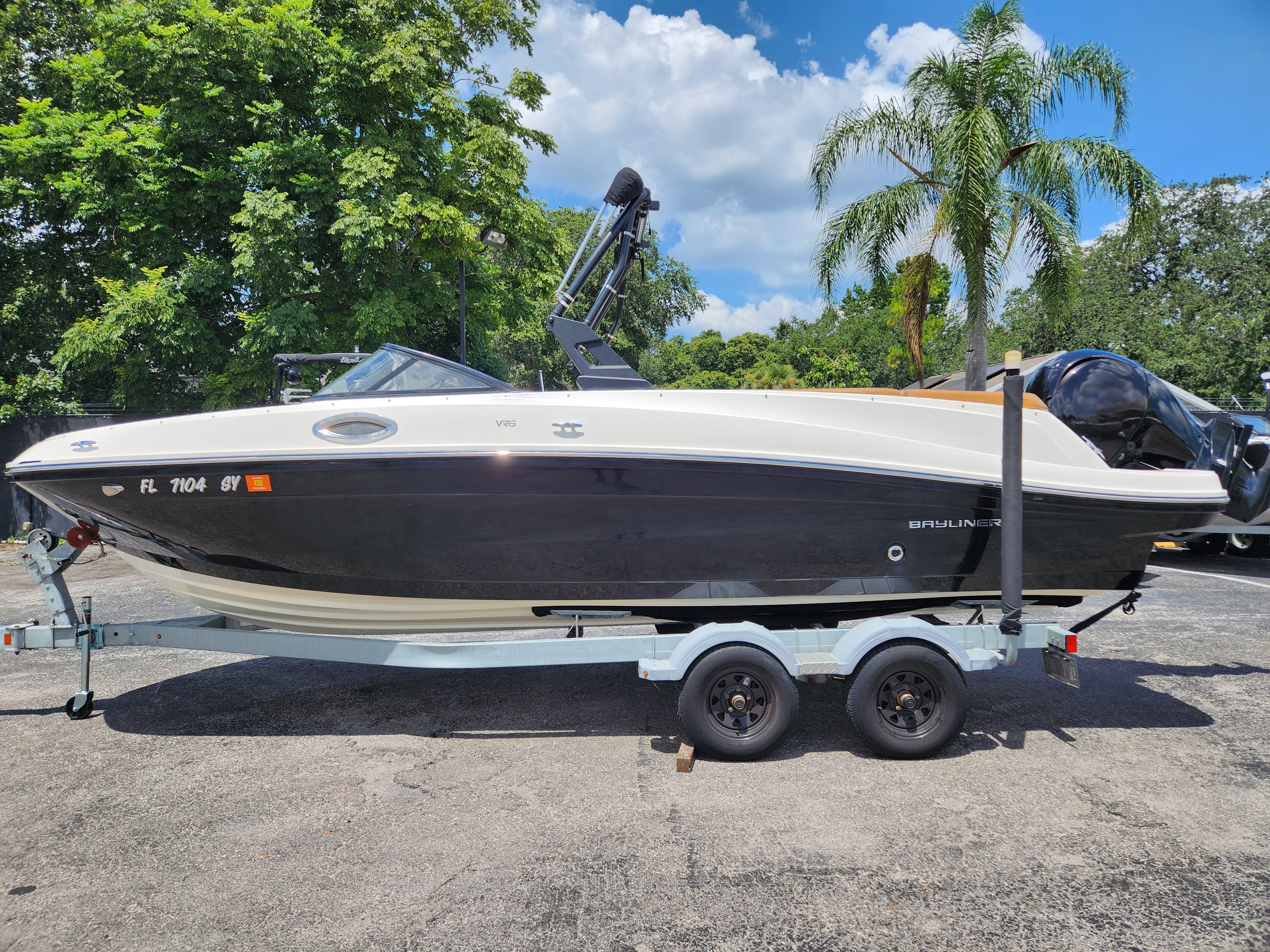 Bayliner VR6 Bowrider OB 2021 Bayliner VR6 Bowrider OB on trailer, parked outdoors with lush greenery background.
