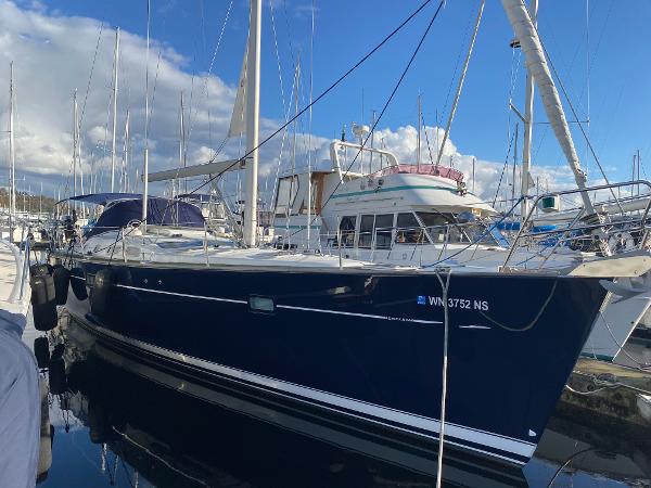 Beneteau 473 2006 Beneteau 473 sailboat docked at marina under blue sky.