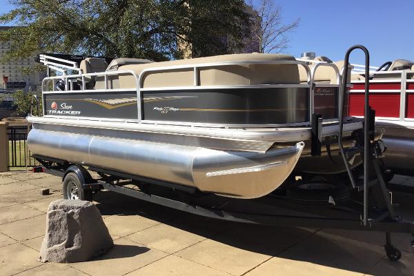 Sun Tracker Party Barge 18 DLX 2025 Sun Tracker Party Barge 18 DLX pontoon boat on trailer, outdoor display.
