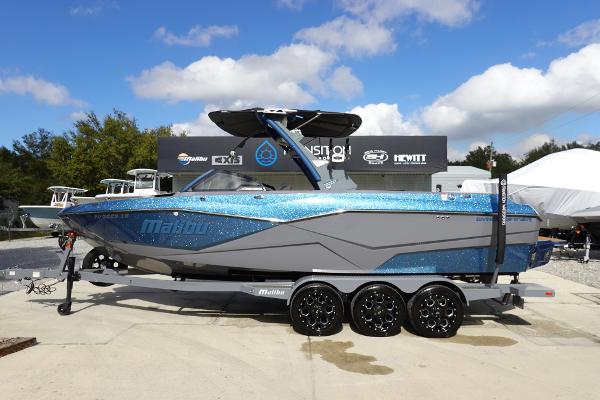 Malibu 25 LSV 2023 Malibu 25 LSV boat on a trailer, displayed outdoors under a blue sky.