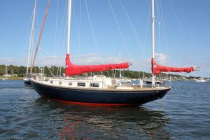 Bristol 40 1982 Bristol 40 sailboat with red sails on calm water, clear sky background.