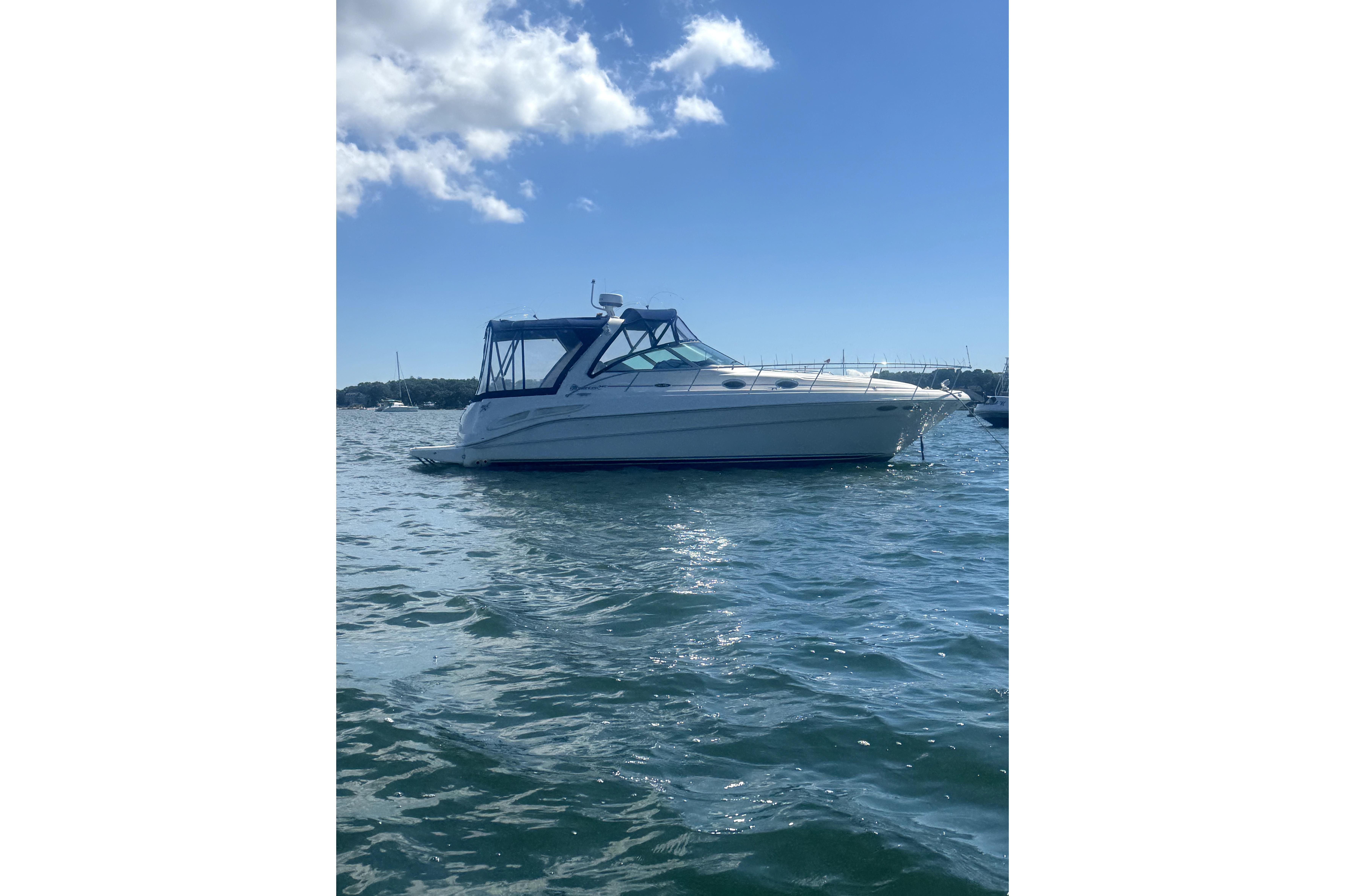 Sea Ray 340 Sundancer 2002 Sea Ray 340 Sundancer boat on calm water under a clear blue sky.