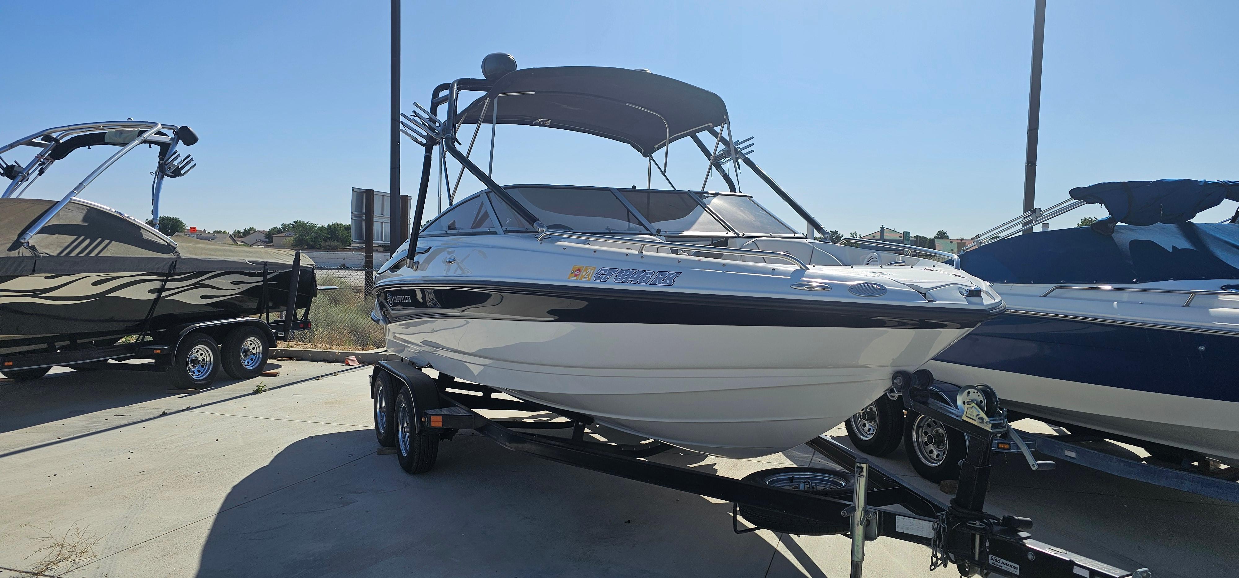 Crownline 210 BR 2006 Crownline 210 BR boat on trailer, parked outdoors under clear sky.