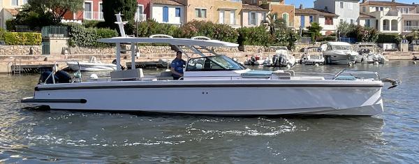 Axopar 37 Sun Top 2023 Axopar 37 Sun Top boat cruising near colorful waterfront houses.