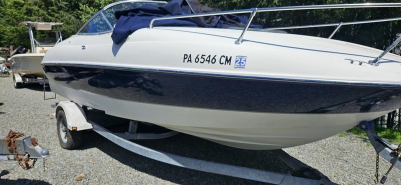 Bayliner 212 Capri Cuddy 2002 Bayliner 212 Capri Cuddy boat on trailer, parked outdoors.