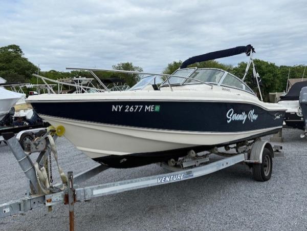 Scout 205 Dorado 2006 Scout 205 Dorado boat on trailer, labeled "Serenity Now," parked outdoors.