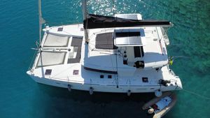 Lagoon 450F 2013 Lagoon 450F catamaran anchored in clear blue water, aerial view.