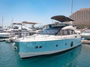 Monte Carlo MC5 2015 Monte Carlo MC5 yacht docked in marina, clear blue sky, luxury boats in background.