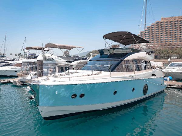 Monte Carlo MC5 2015 Monte Carlo MC5 yacht docked in marina, clear blue sky, luxury boats in background.