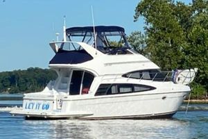 Carver 360 Sport Sedan 2003 Carver 360 Sport Sedan yacht cruising on a serene lake with lush greenery.