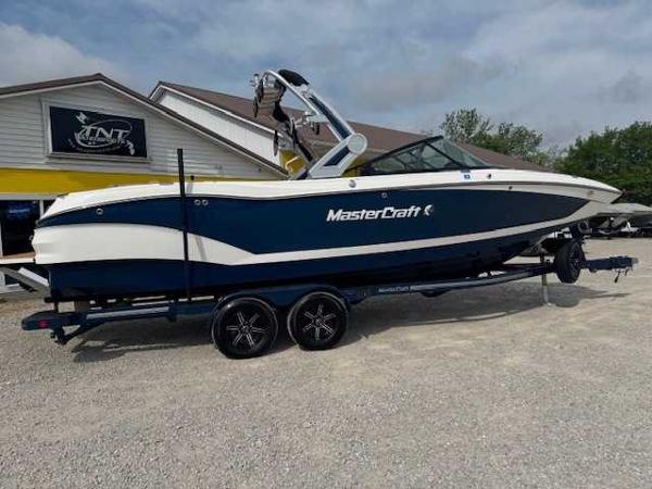 MasterCraft X26 2022 MasterCraft X26 boat on trailer, parked outdoors near a building.