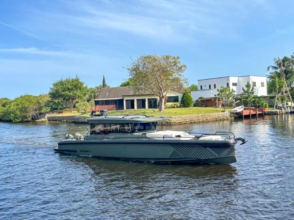 BRABUS Shadow 900XC 2024 BRABUS Shadow 900XC yacht cruising on a scenic river near luxury homes.