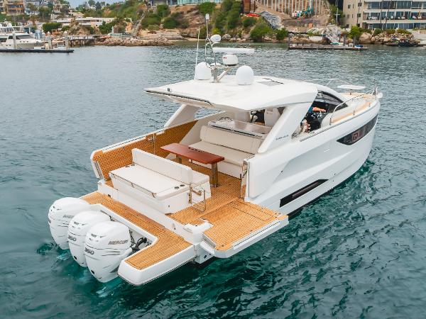 Jeanneau DB/43 OB 2024 Jeanneau DB/43 OB luxury boat with triple outboard engines on open water.