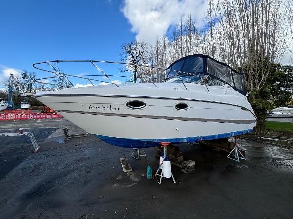 Maxum 2700 SCR 2000 Maxum 2700 SCR boat on stands, outdoors, with blue trim and overcast sky.