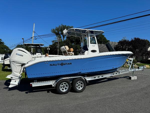 NauticStar 242 Offshore 2025 NauticStar 24 OSL boat on trailer, blue hull, Yamaha engine, sunny day.