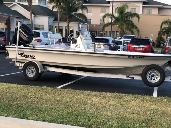 Mako 18 LTS 2016 Mako 18 LTS boat on trailer in parking lot, surrounded by cars and palm trees.
