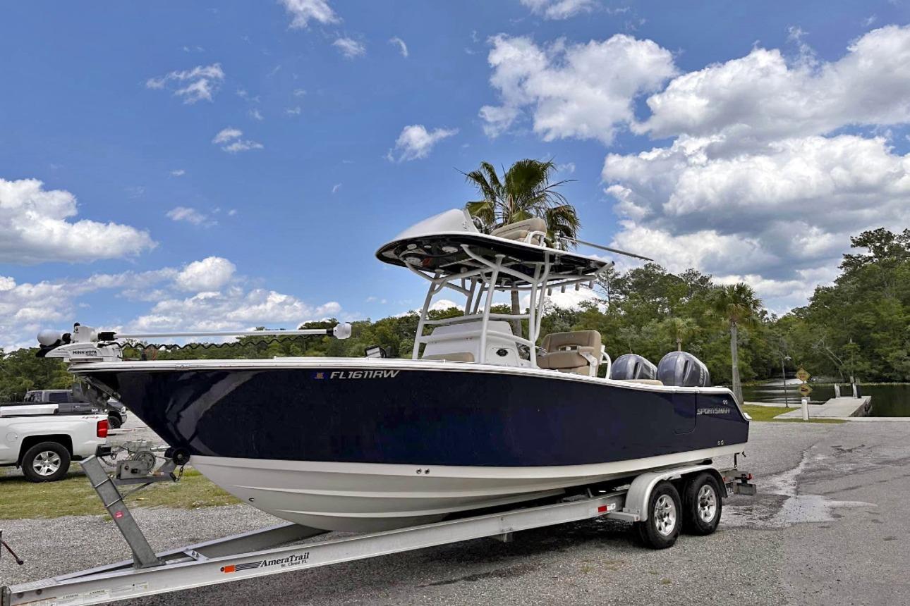 Sportsman Open 252 Center Console 2018 Sportsman Open 252 Center Console boat on trailer, parked near a scenic waterway.