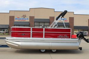 Sun Tracker Party Barge 16 DLX 2026 Sun Tracker Party Barge 16 DLX pontoon boat, red and silver, at dealership.