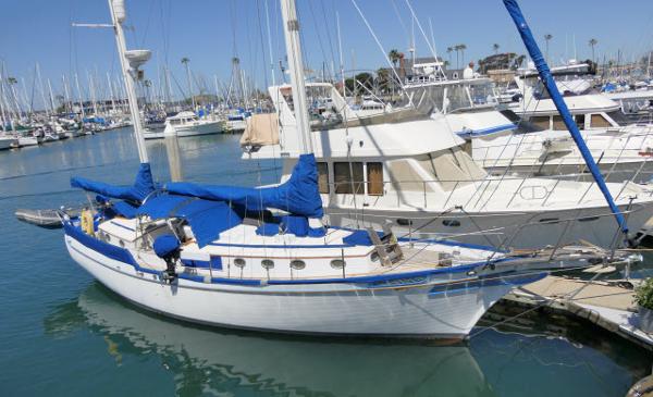 Brewer 45 Ketch 1978 Brewer 45 Ketch sailboat docked in a marina, featuring blue covers and clear skies.
