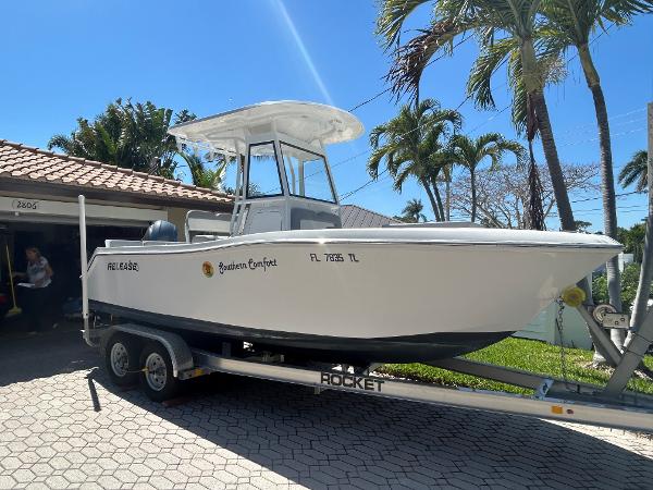 Release 210 RX 2023 Release 210 RX boat on trailer, parked in driveway with palm trees in background.