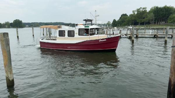 Ranger Tugs R-27 2017 Ranger Tugs R-27 boat docked on a calm lake.