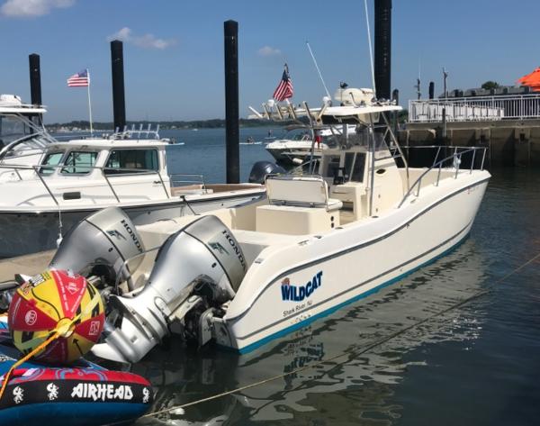 World Cat 266 Sport Fish 1998 World Cat 270TE boat docked with dual engines and inflatable water toy.