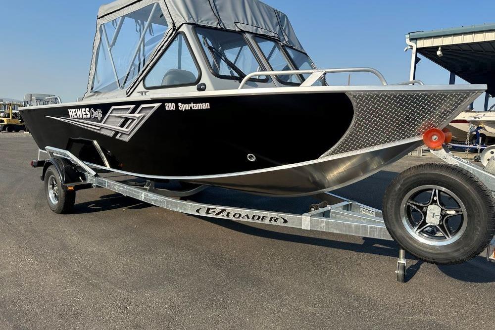 Hewescraft 200 Sportsman 2025 Hewescraft 200 Sportsman boat on EZ Loader trailer, parked outdoors.