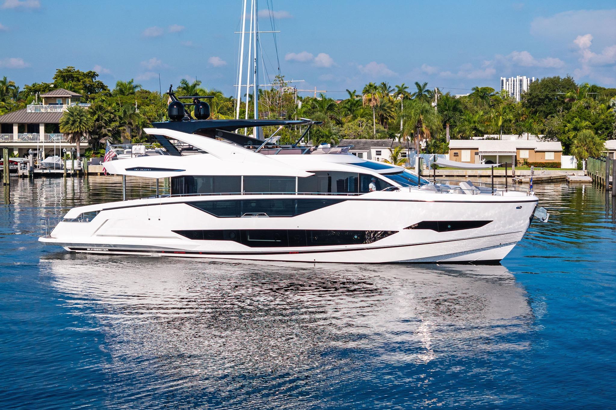 Sunseeker Ocean 90 2024 Sunseeker Ocean 90 yacht cruising on a serene waterway, surrounded by lush greenery.