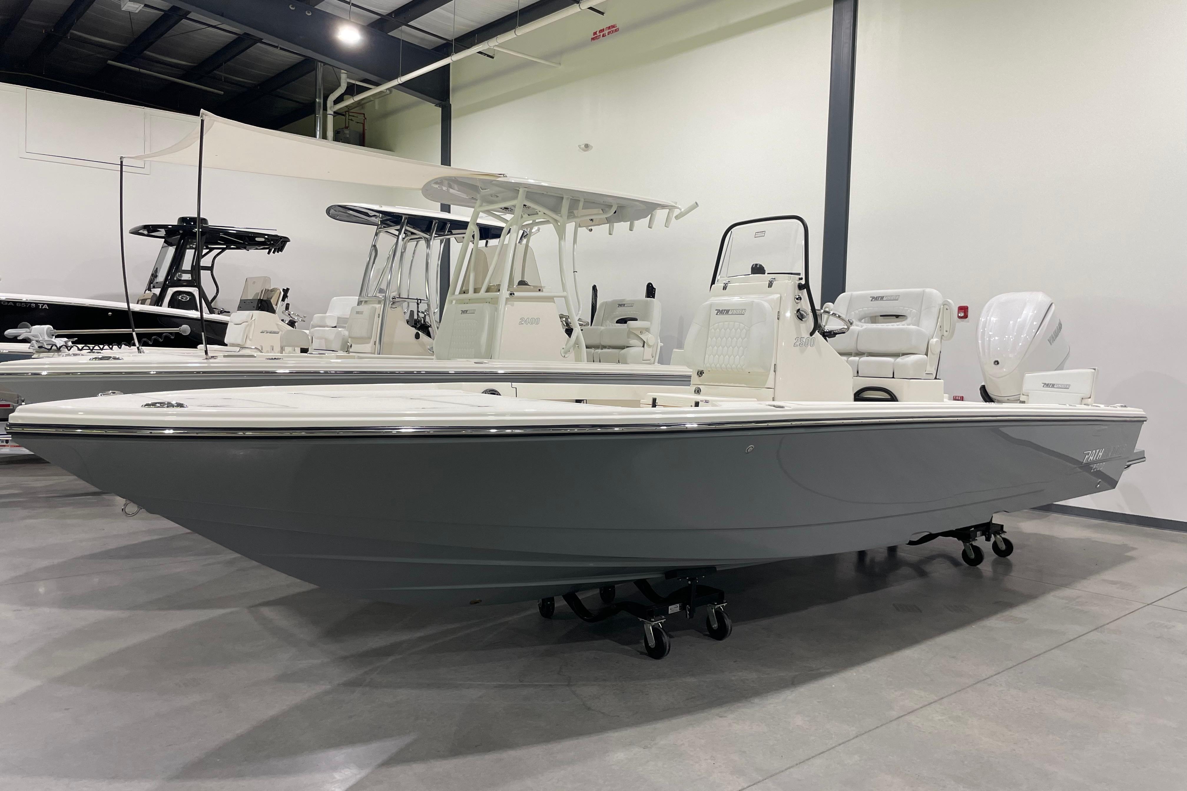 Pathfinder 2500 Hybrid 2026 Pathfinder 2500 Hybrid boat in showroom, sleek design, white and gray color scheme.