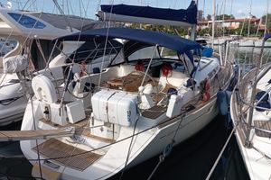 Jeanneau Sun Odyssey 49 2005 Jeanneau Sun Odyssey 49 sailboat docked in marina, featuring blue canopy and wooden deck.