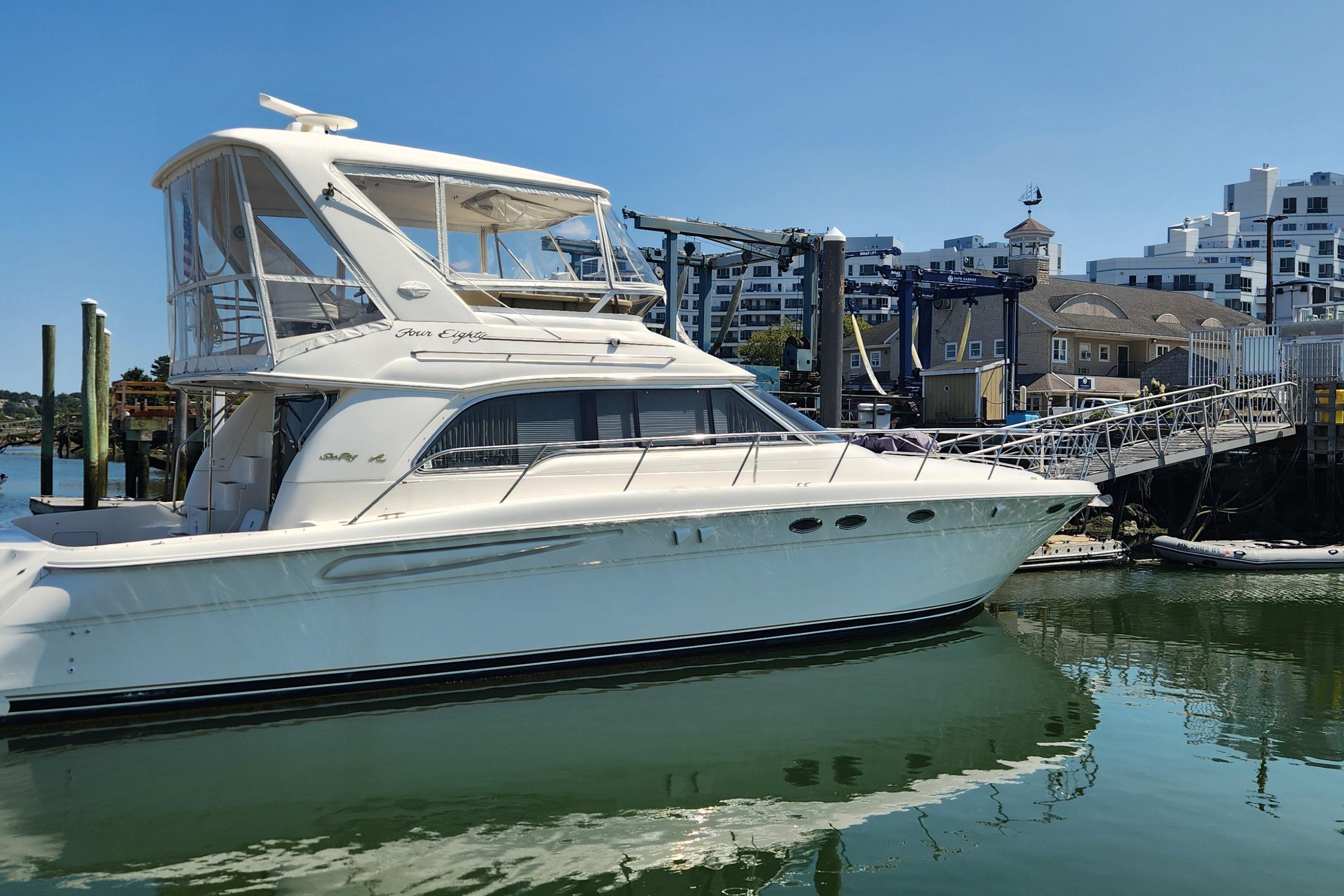 Sea Ray 480 Sedan Bridge 1999 Sea Ray 480 Sedan Bridge yacht docked at a marina with modern buildings.