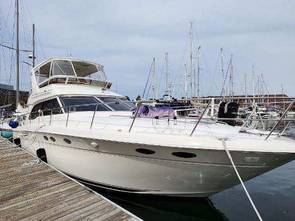 Sea Ray Sedan Bridge 1999 Sea Ray Sedan Bridge yacht docked at marina, showcasing sleek design and spacious deck.