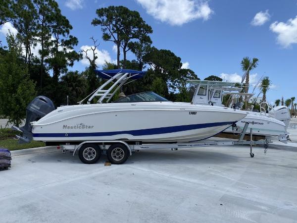 NauticStar 243 DC 2019 NauticStar 243 DC boat on trailer, parked outdoors under blue sky.