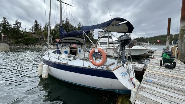 Peterson 35 1982 Peterson 35 sailboat docked by a wooden pier, overcast sky.