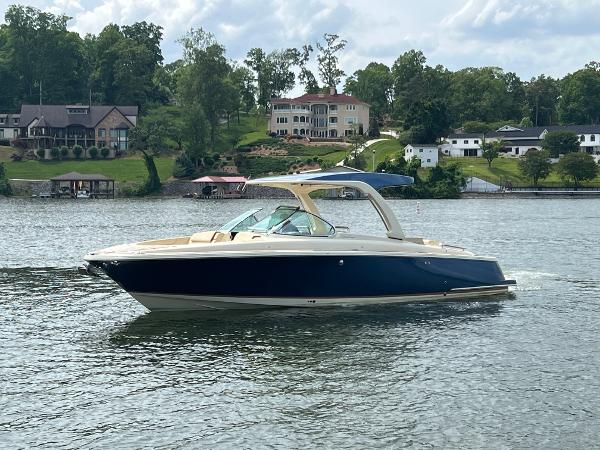 Chris-Craft Launch 31 GT 2020 Chris-Craft Launch 31 GT boat cruising on a lake with houses in the background.