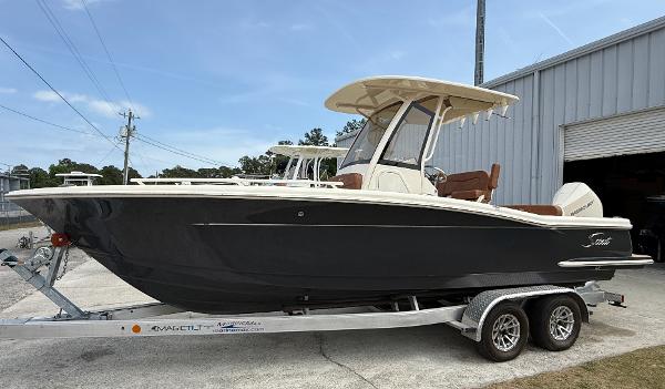Scout 240 XSF 2024 Scout 240 XSF boat on trailer, parked outside a warehouse.
