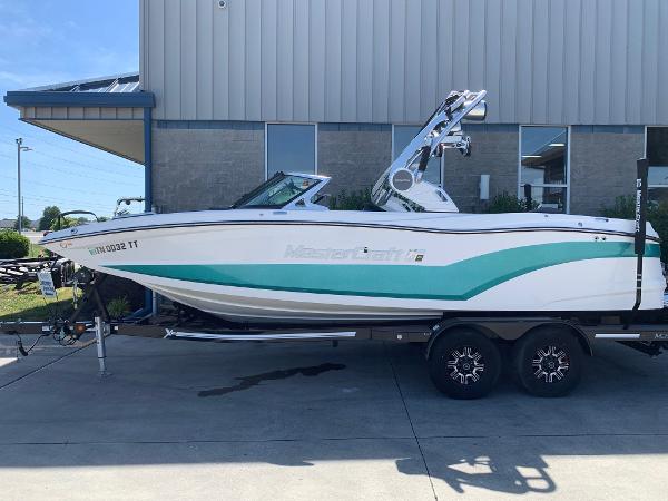 MasterCraft XT22 2018 MasterCraft XT22 boat on a trailer outside a building.