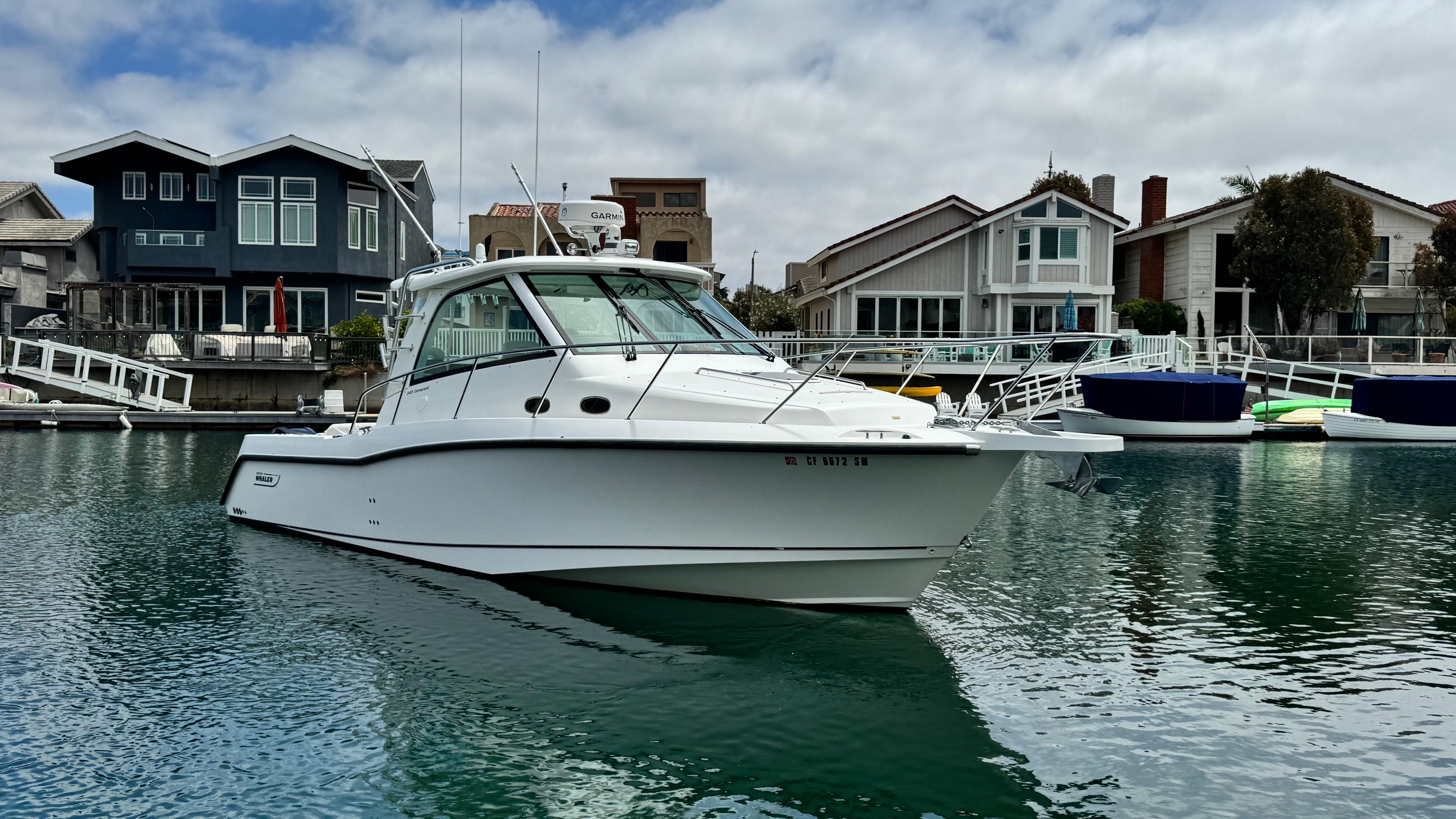 Boston Whaler 345 Conquest 2008 Boston Whaler 345 Conquest boat docked near waterfront homes.