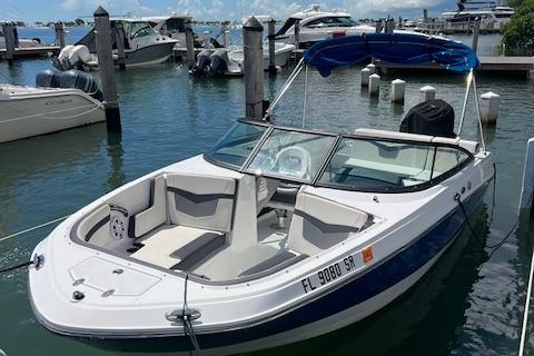 Monterey M-225 2020 Monterey M-225 boat docked at marina with blue canopy.