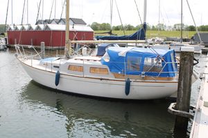 Sailboat Great Dane 28 1969 Great Dane 28 sailboat docked in a marina with blue canopy.