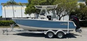 Mako 214 Center Console 2024 Mako 214 CC boat on a trailer, parked outdoors.