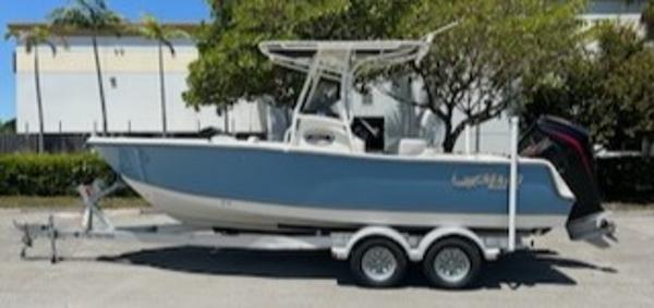 Mako 214 CC 2024 Mako 214 CC boat on a trailer, parked outdoors.