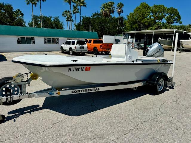 Rabco Buccaneer 2021 Rabco Buccaneer boat on trailer in parking lot, surrounded by vehicles and trees.