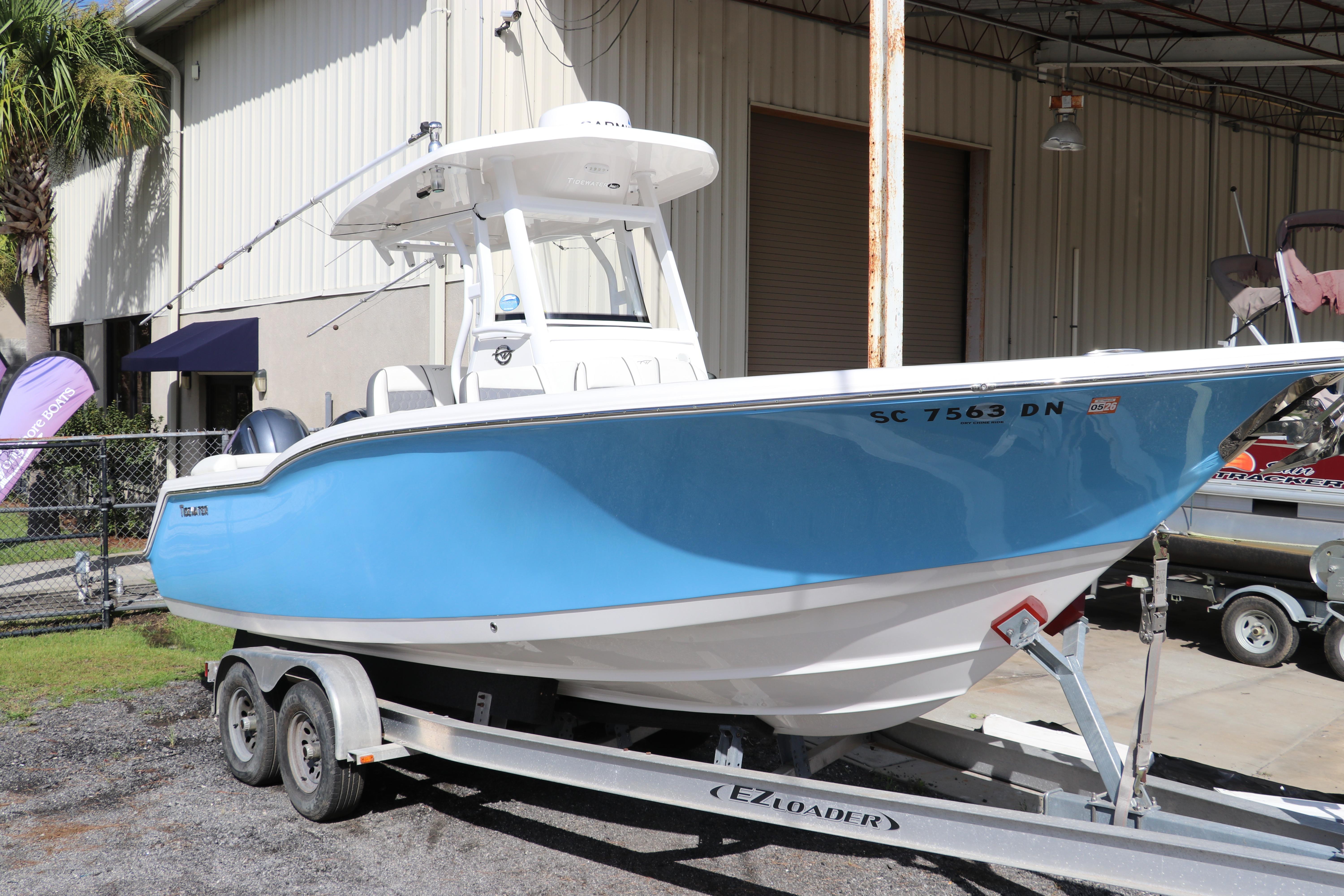 Tidewater 252 LXF 2020 Tidewater 252 LXF boat on trailer, blue hull, parked outside a warehouse.