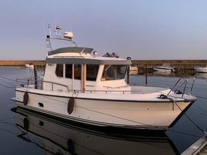 Targa 27.2 2018 Targa 27.2 boat docked in calm waters at sunset.