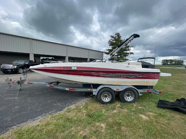 Bayliner 197 2011 Bayliner 197 boat on a trailer, parked outdoors under cloudy skies.
