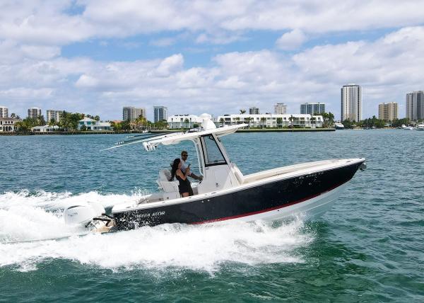 Regulator 23 2024 Regulator 23 boat cruising on water with city skyline in background.