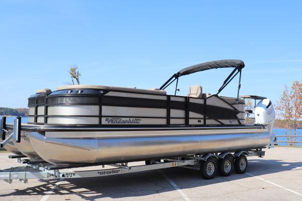 Vanderbilt 700T 2023 Vanderbilt 700T pontoon boat on trailer, parked near a lake.