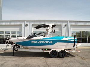 Supra SL 450 2023 Supra SL 450 boat on trailer, parked outside a building.