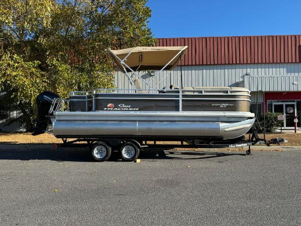 Sun Tracker SportFish 20 DLX 2025 Sun Tracker SportFish 20 DLX pontoon boat on trailer, parked outdoors.